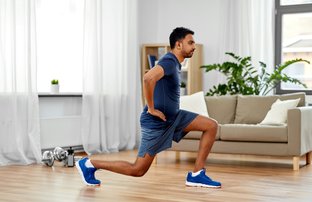 Man at home doing lunges