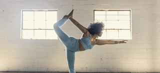 Woman doing yoga in bright sunny room