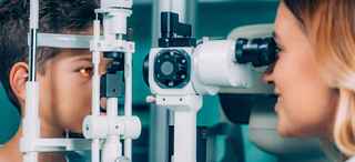 Ophthalmologist examining boy's eyes with slit lamp