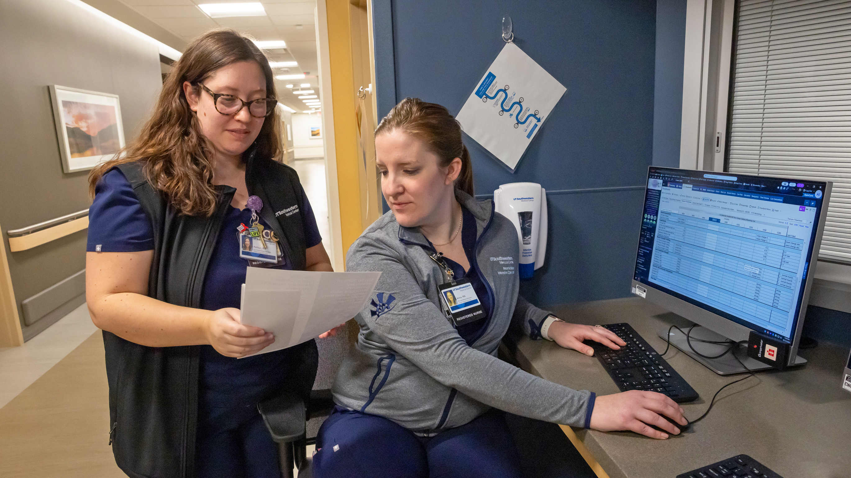 Two nurses looking at a piece of paper together
