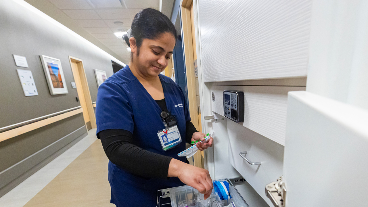 A female nurse pulling supplies out of a drawer.