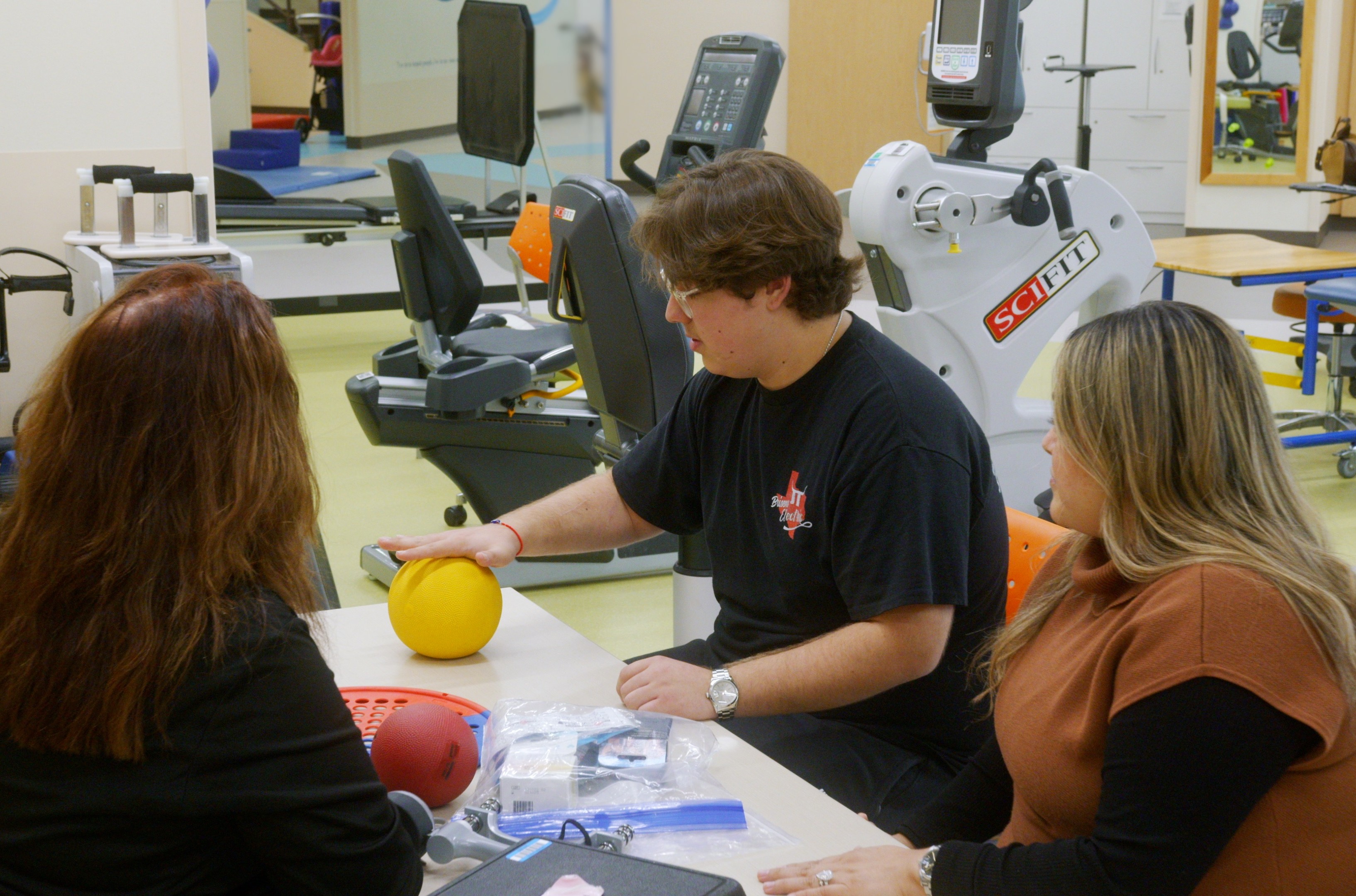 Kevin Briseno (center) works with occupational therapist Debbie Tilton Rains (left) while mom Marina Melo watches