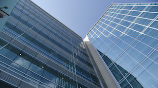 The image shows a modern office building with a glass facade.