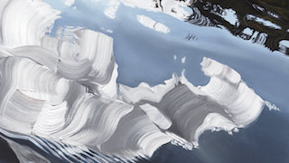 An artistic image showing the distorted reflection of buildings or clouds on the surface of the water, creating a visually intriguing abstract pattern.