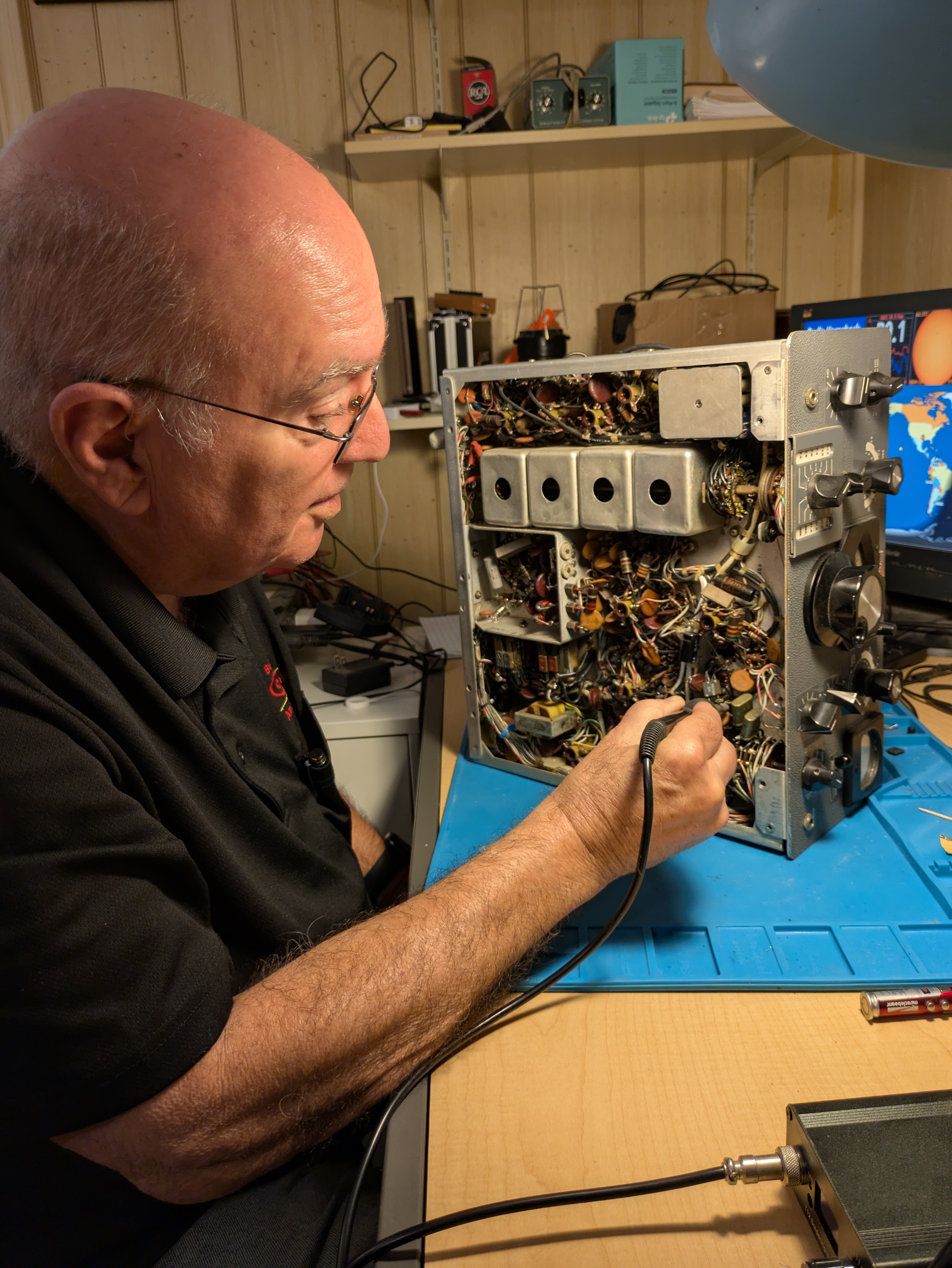 Keith "Bud" Leavell works on a ham radio in his home workshop.