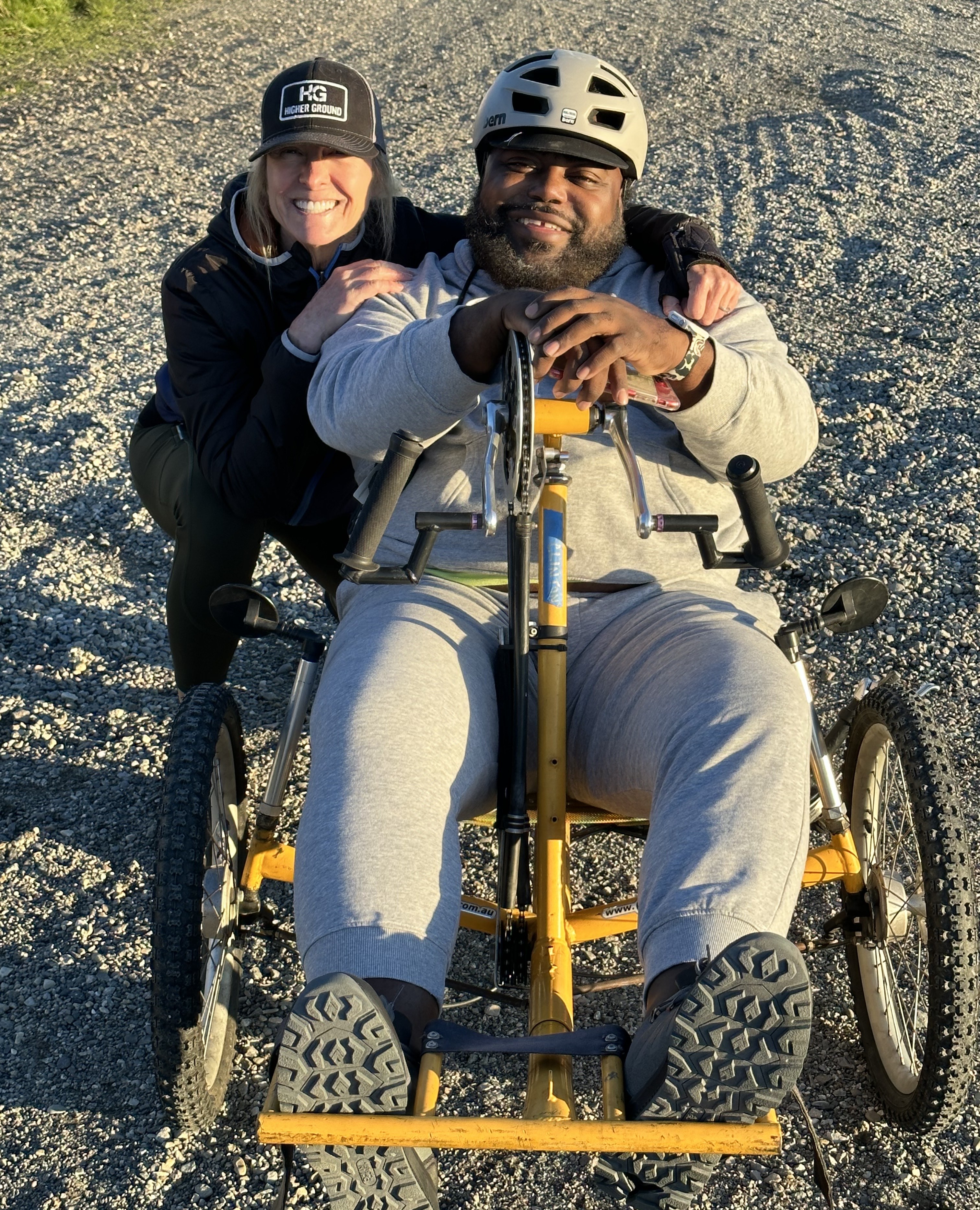 Patient Clinton Adger using wheelchair outdoors with a woman