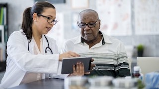 physician showing a patient a computer tablet