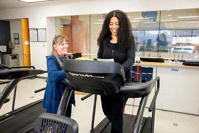 Woman on treadmill exercising with a provider