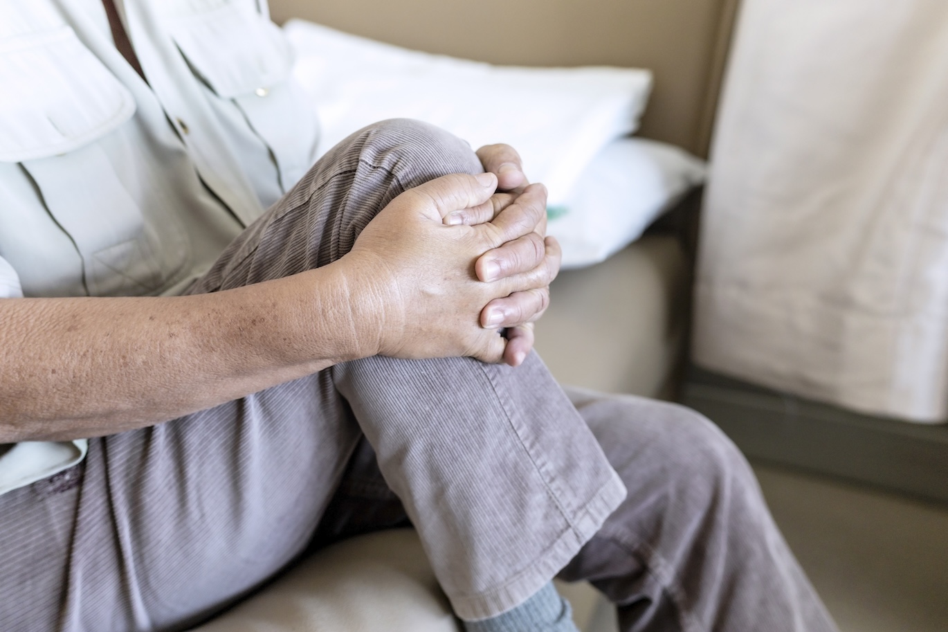 The old man suffering from knee pain at home