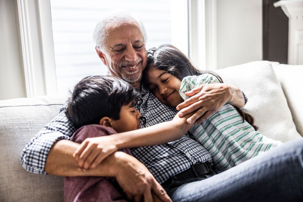 Grandfather hugging his young grandchildren.
