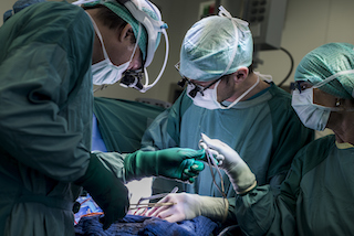 Surgeons performing heart surgery in an operating room
