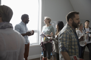 A group of people engage in conversations during a social gathering in a well-lit room."