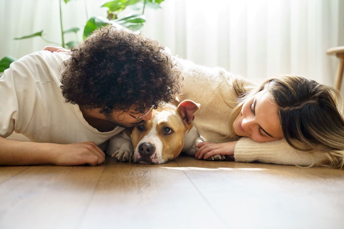 Couple lying on floor with their dog.