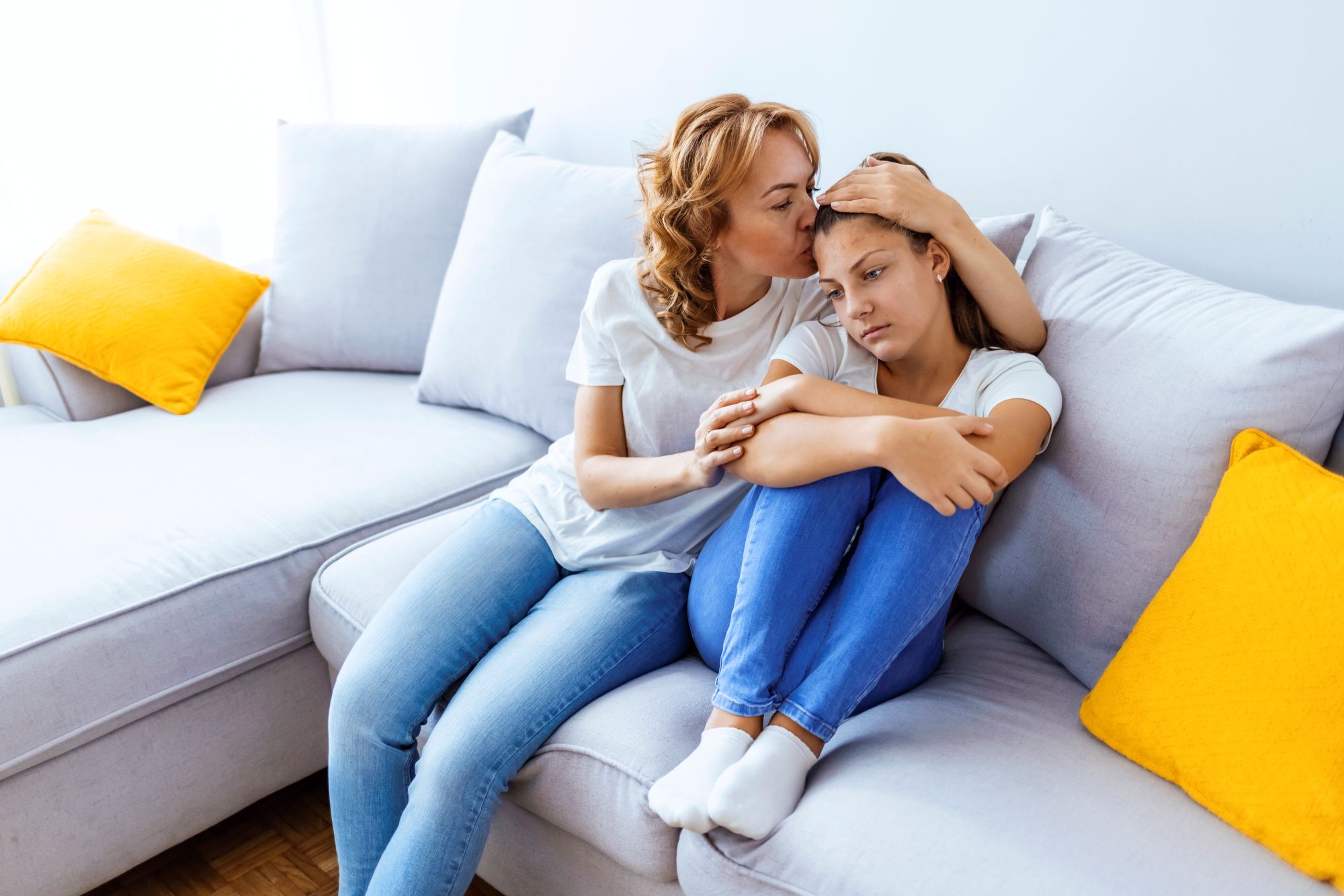 Mother comforts her teenage daughter.