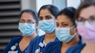 A row of nurses wearing masks