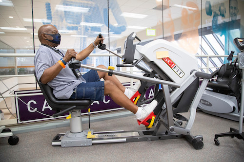 A man wearing a face mask while working out in a gym.