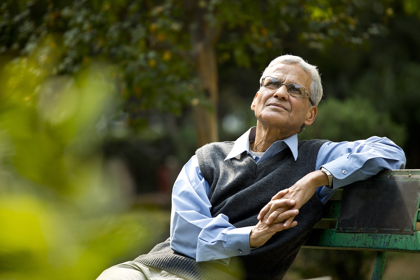 Senior man sitting outside on a park bench.