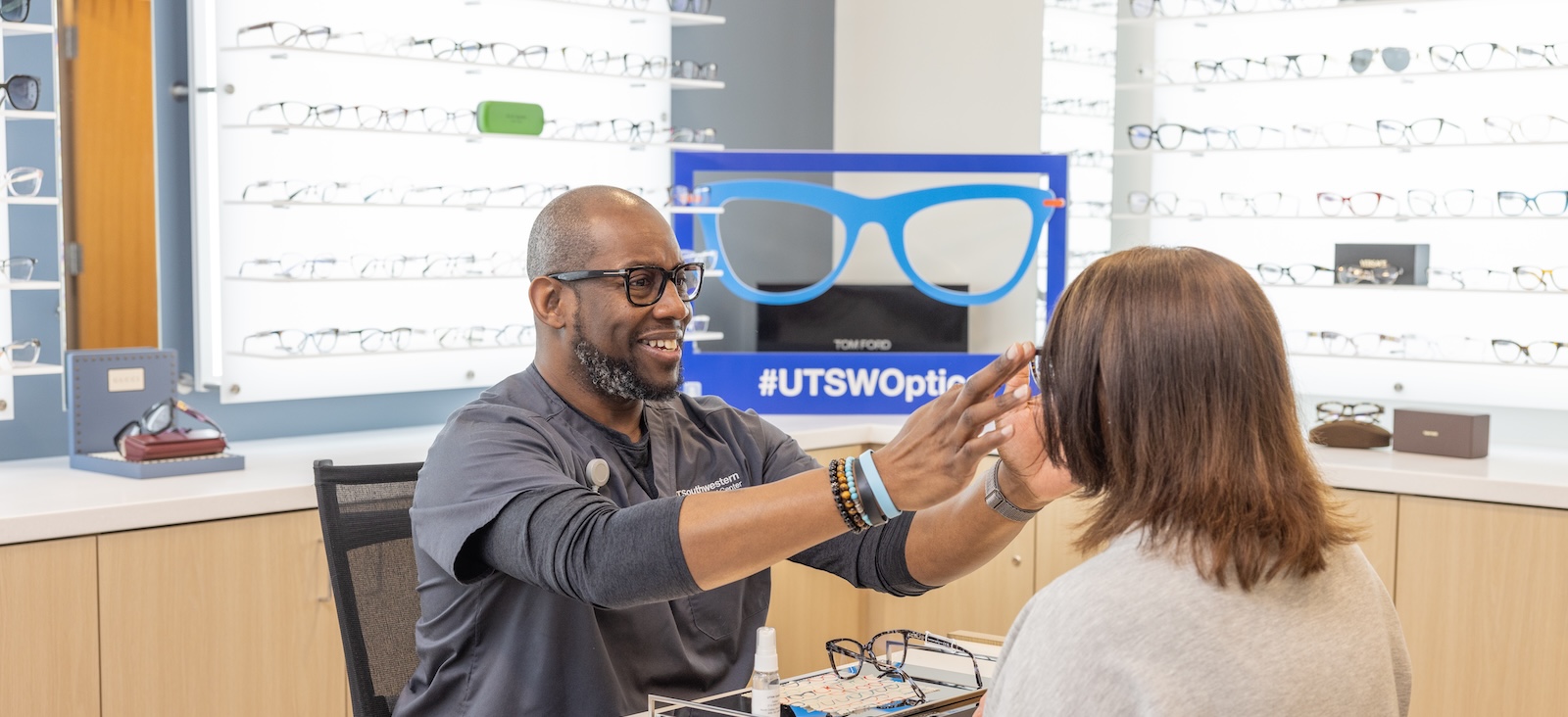 An optician helps a patient with glasses