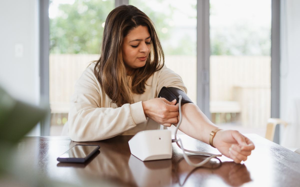 Woman checks her blood pressure at home
