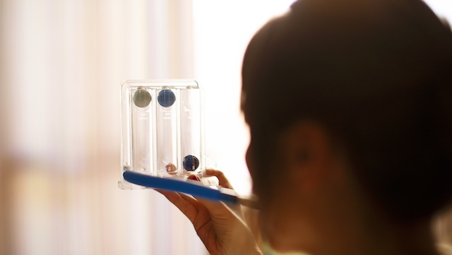 Woman using spirometer