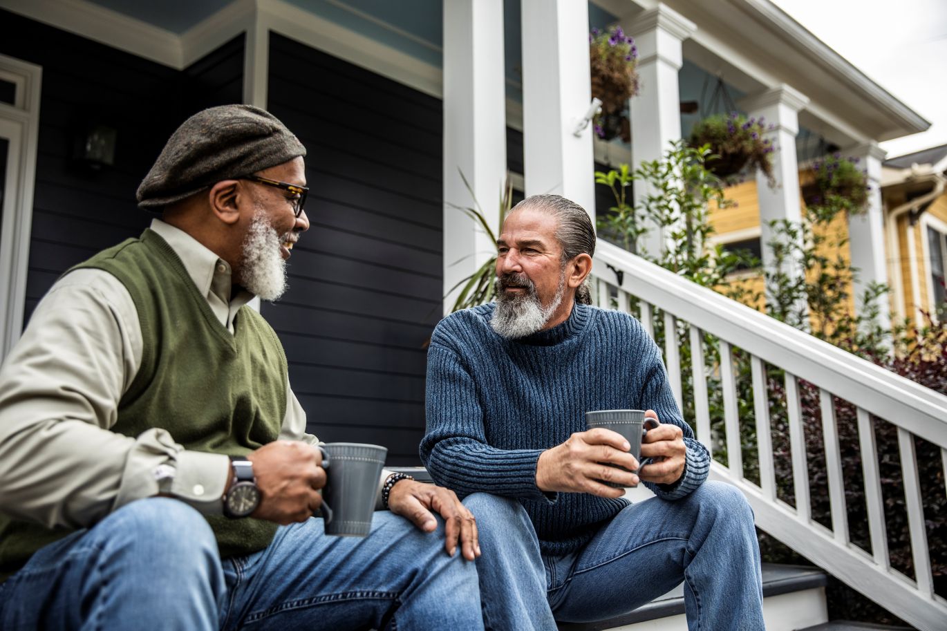Two men visit while drinking coffee