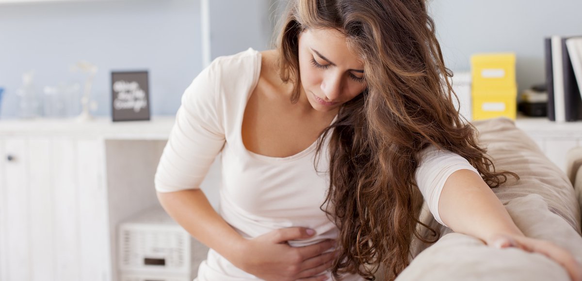 woman holding stomach as she is feeling sick after chemotherapy
