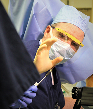 Surgeon performing brachytherapy internal beam procedure.