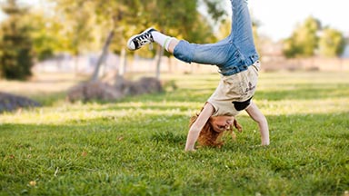 child doing cartwheels on grass