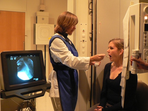 caregiver examining a patient's throat