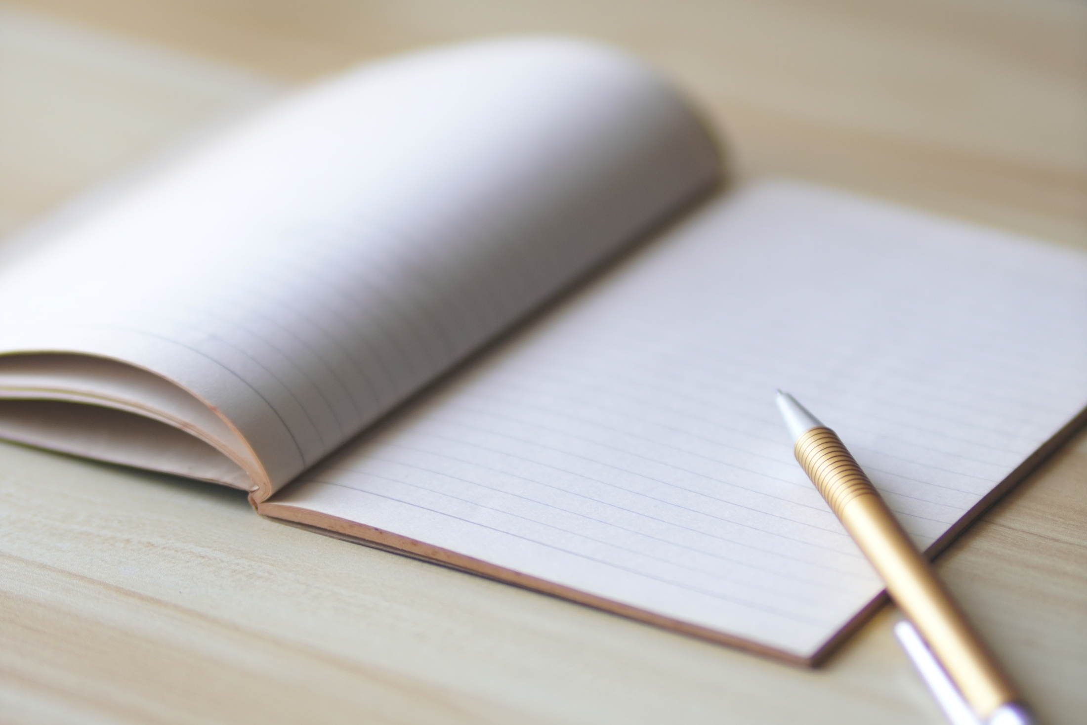 open notebook with mechanical pencil lying across one corner
