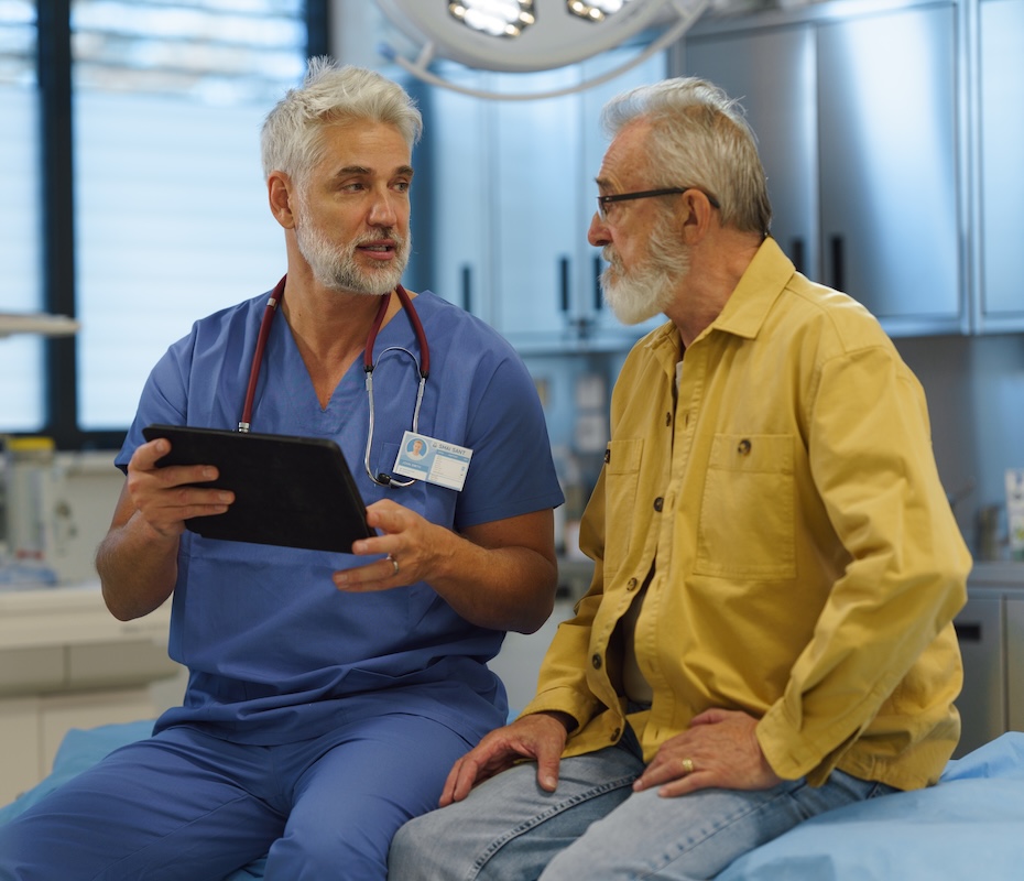 Doctor, holding a tablet, talking to patient