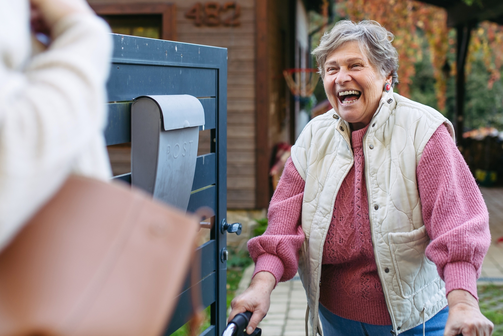 Older woman walking outdoors toward mailbox