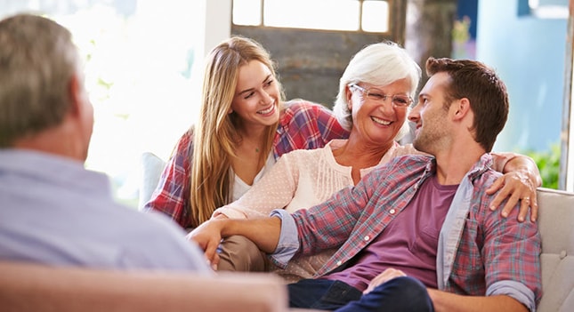 A cheerful family relaxes on a couch in their living room