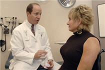 A doctor and woman in discussion in a doctor's office.