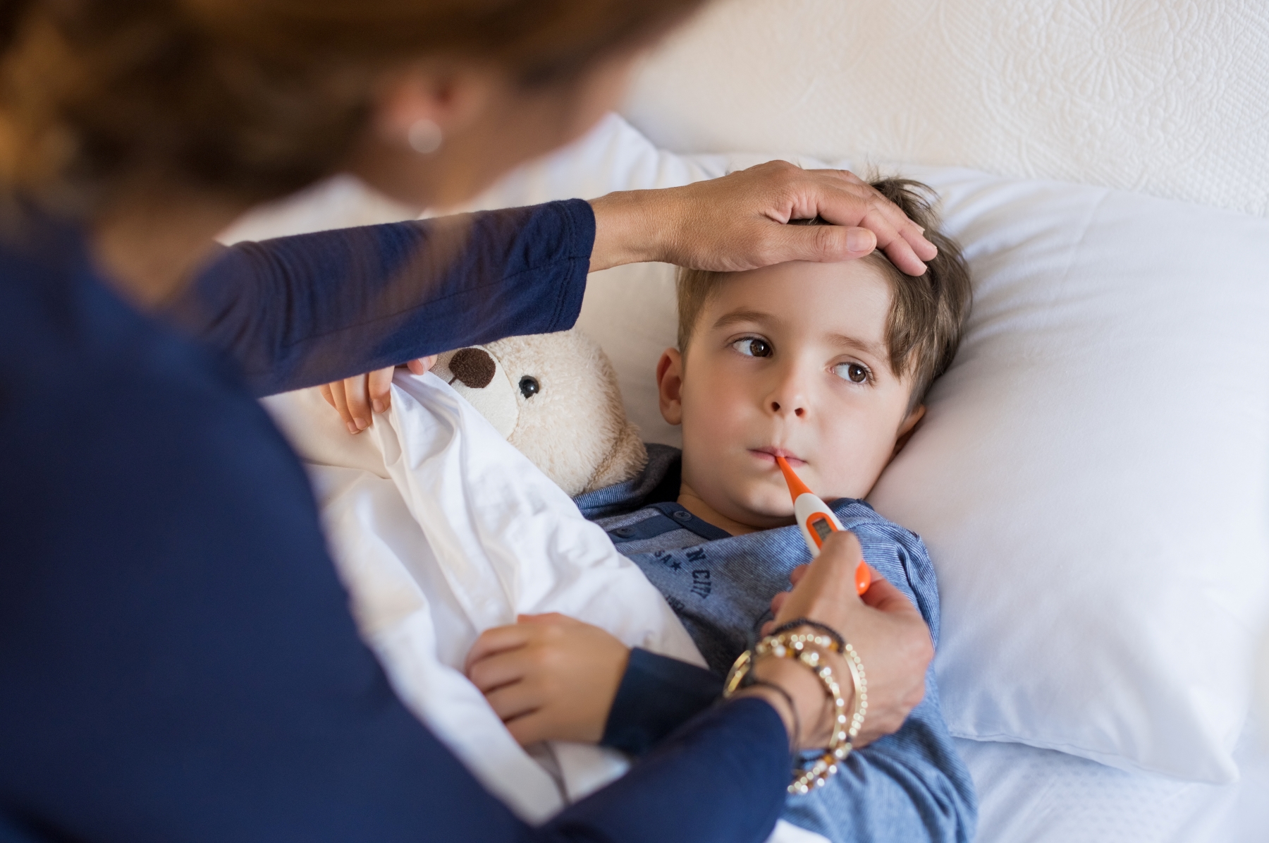 Woman checking temperature on sick child