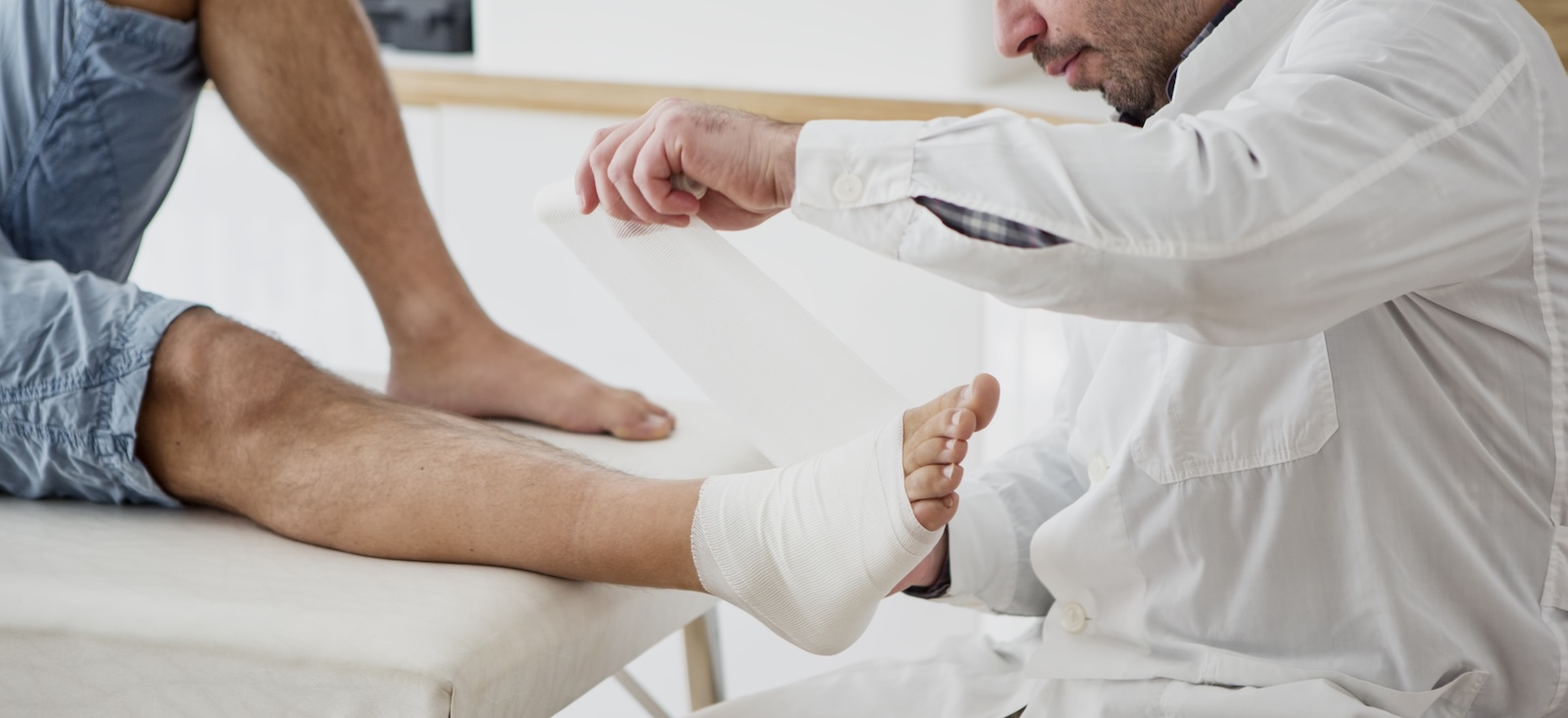 Doctor bandages a patient's ankle