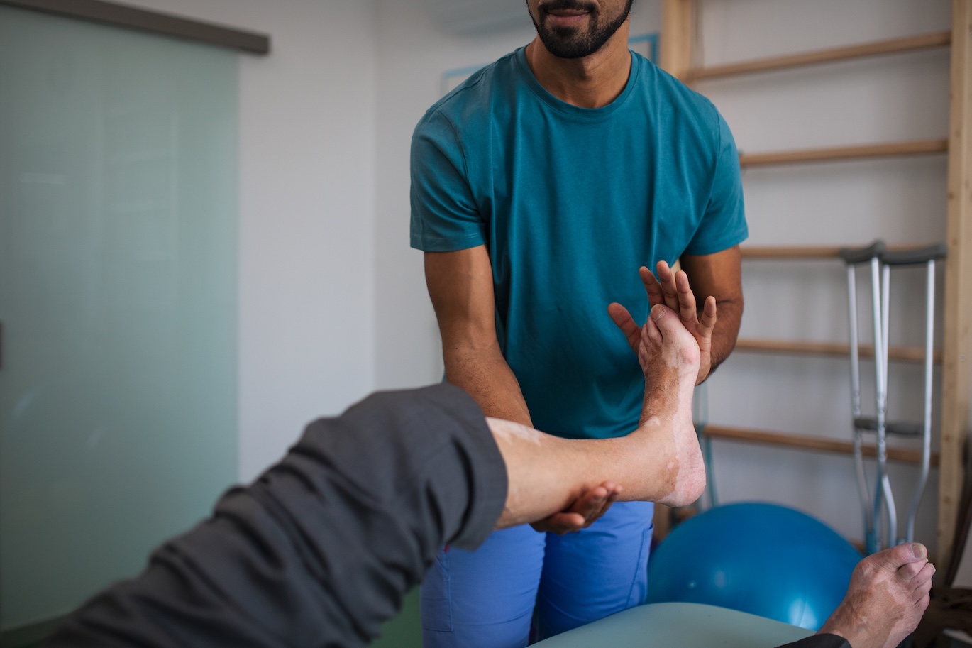 Physiotherapist stretching a senior patient's foot and ankle