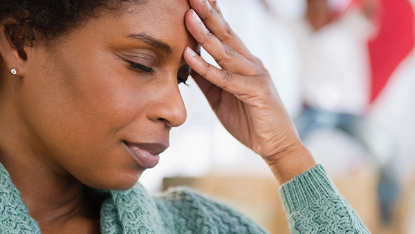 Woman in pain holding forehead
