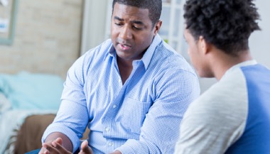 A father providing guidance to his teenage son on quitting smoking