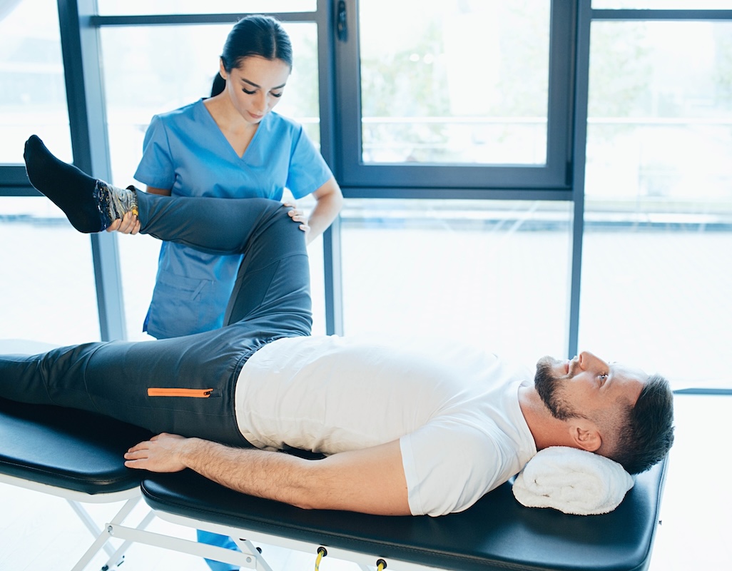 Man on table receiving physical therapy on hip