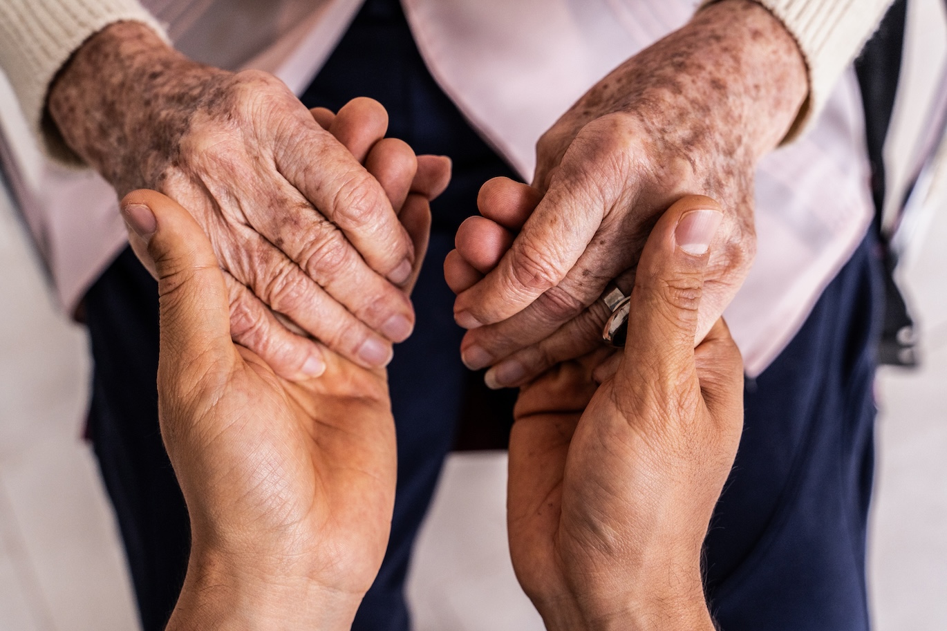 caregiver holding hands of an older patient