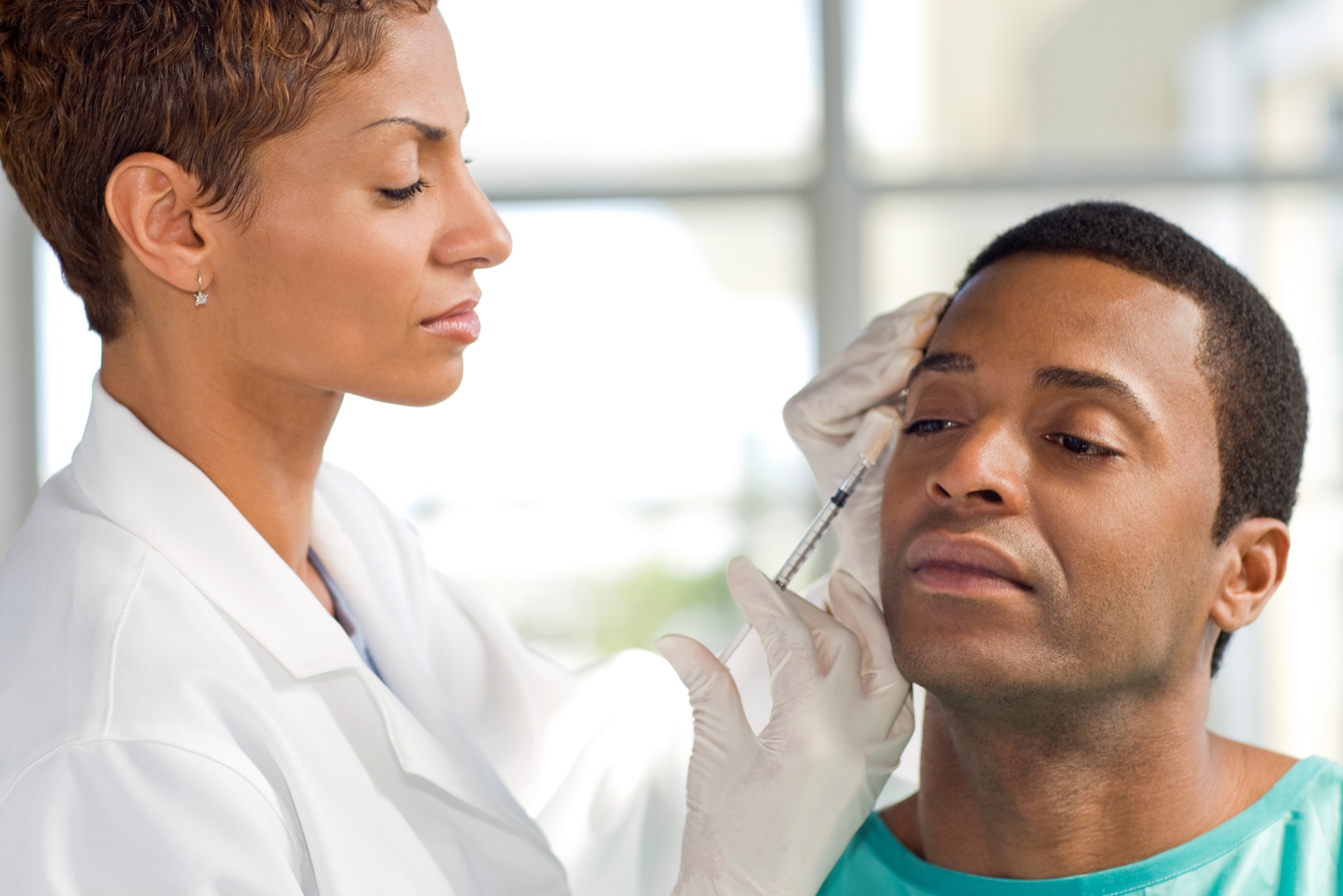 Doctor is giving a male patient an injection in the face to smooth out wrinkles