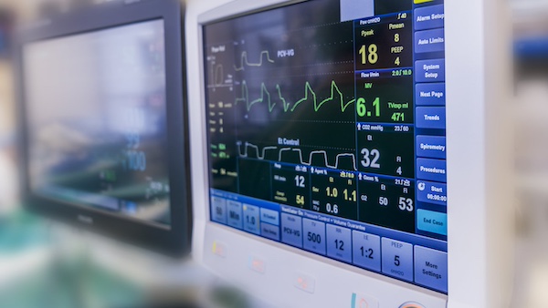 Close-up of a medical monitor displaying vital signs and heart rate