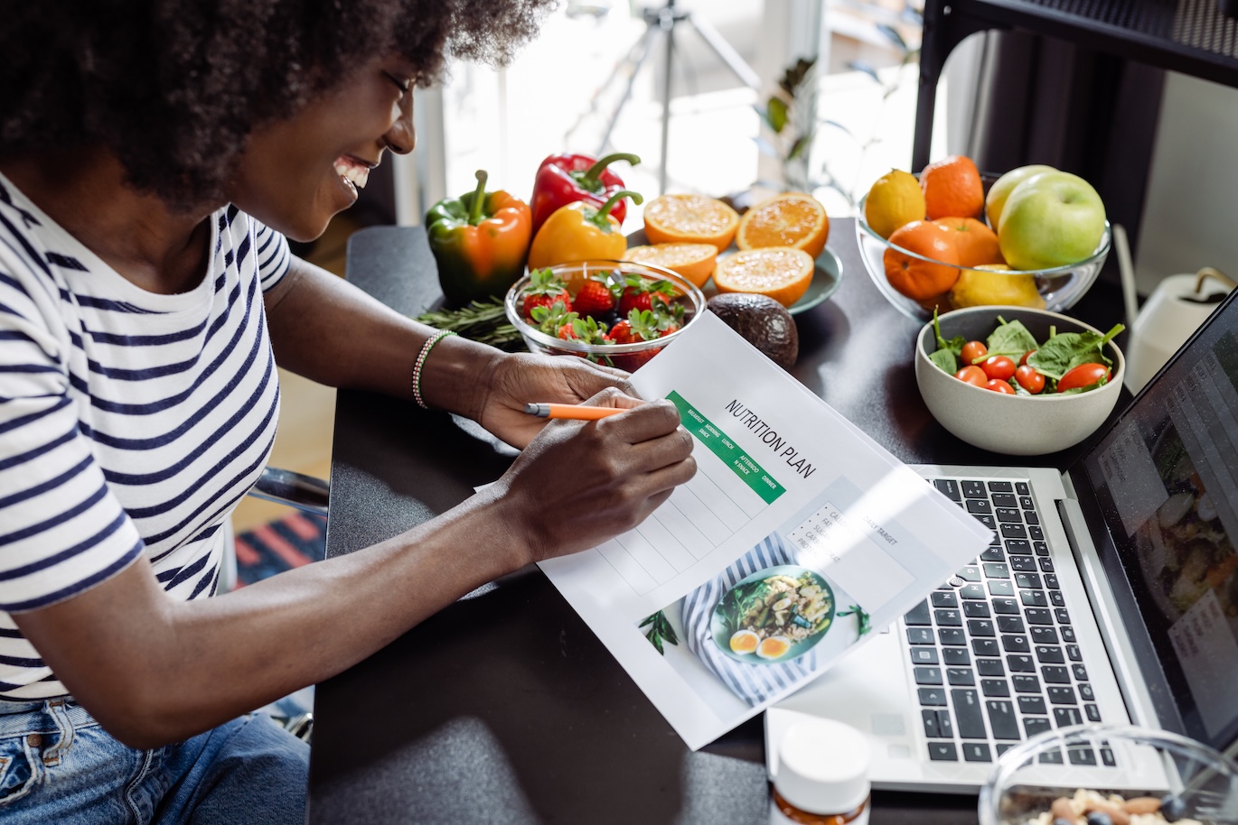 A cheerful dietician is making a nutrition plan for her clients.