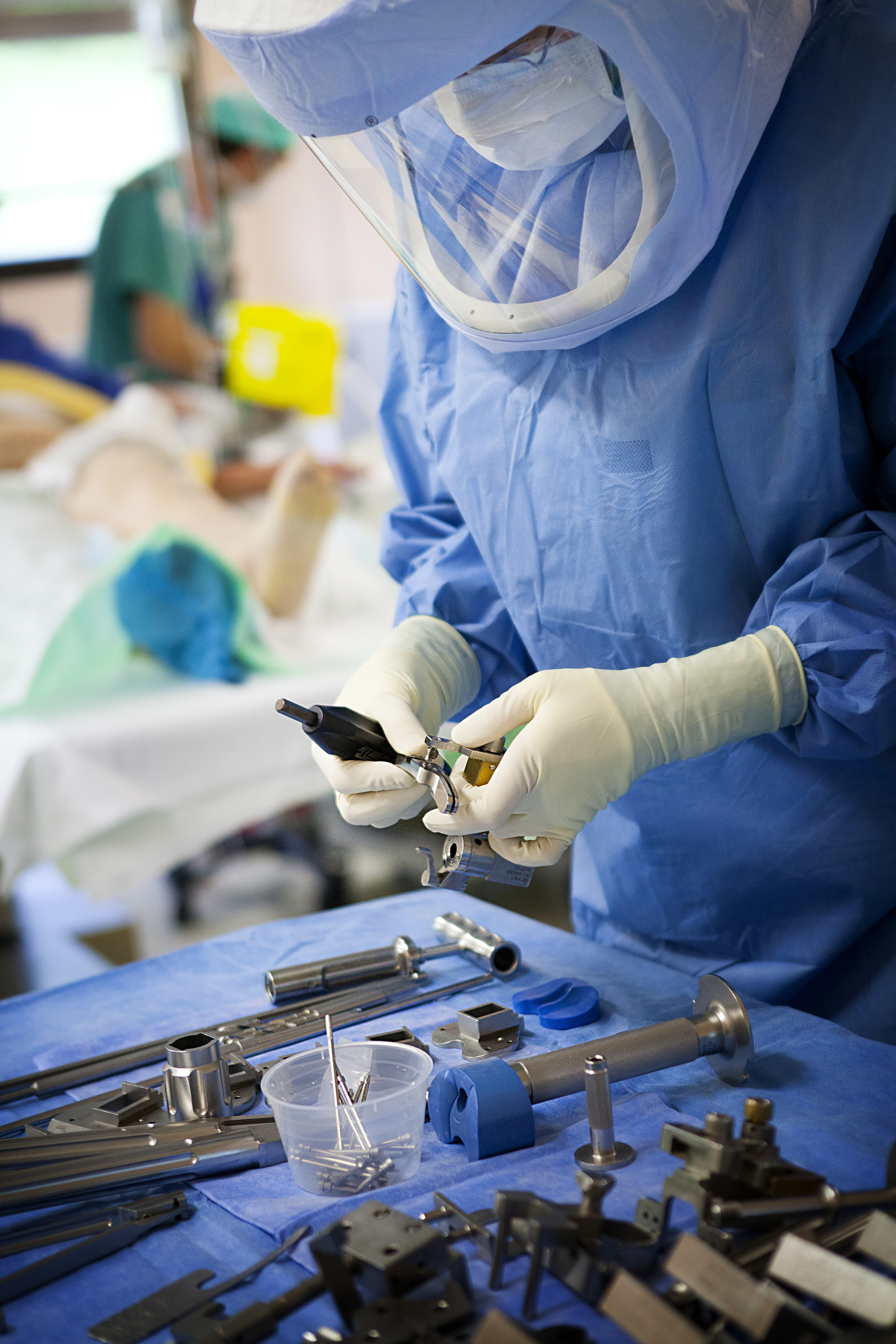 Surgeon in protective suit, examining tools