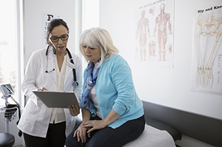 A doctor conducts an examination of a patient in a hospital room.