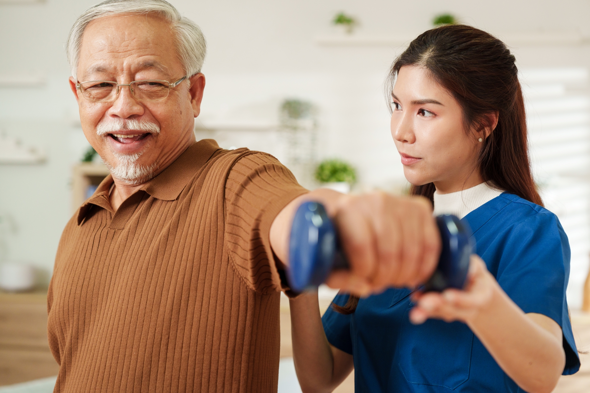 Older man lifting hand weights during physical therapy