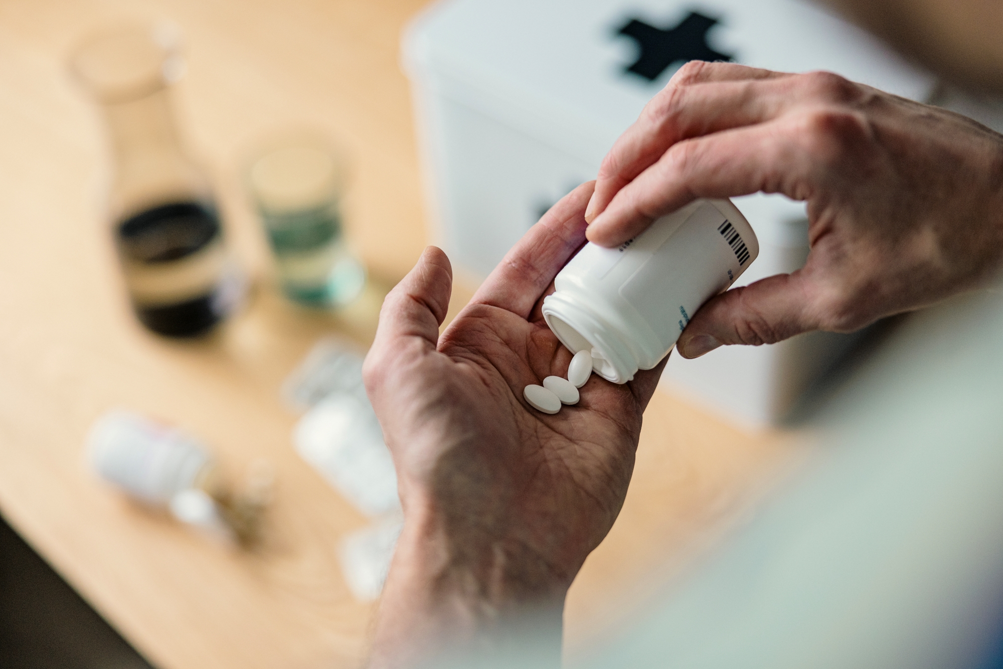 Person shaking pills from bottle into hand