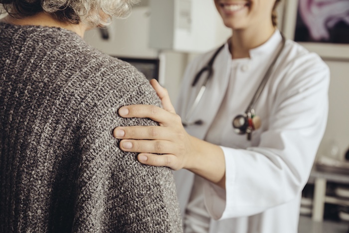 A provider comforts a female senior patient