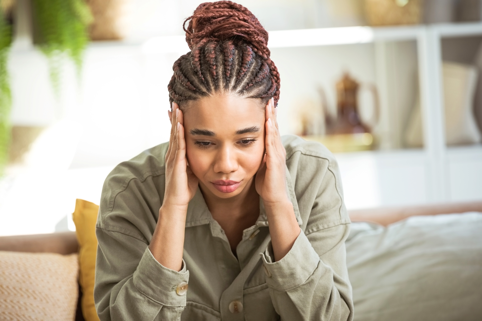 Woman holding head between hands and looking stressed